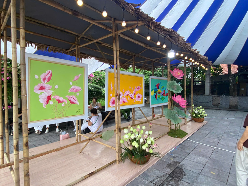 Hình ảnh các thành viên nữ check-in trước không gian tranh sen rực rỡ.